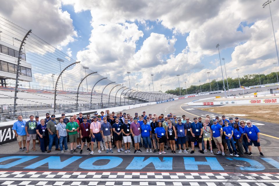 Image of all the employee attendees of our 2024 employee appreciation day. Employees are standing at the racetrack finish line. 