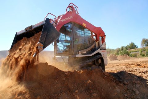 construction equipment unloading dirt at a job site